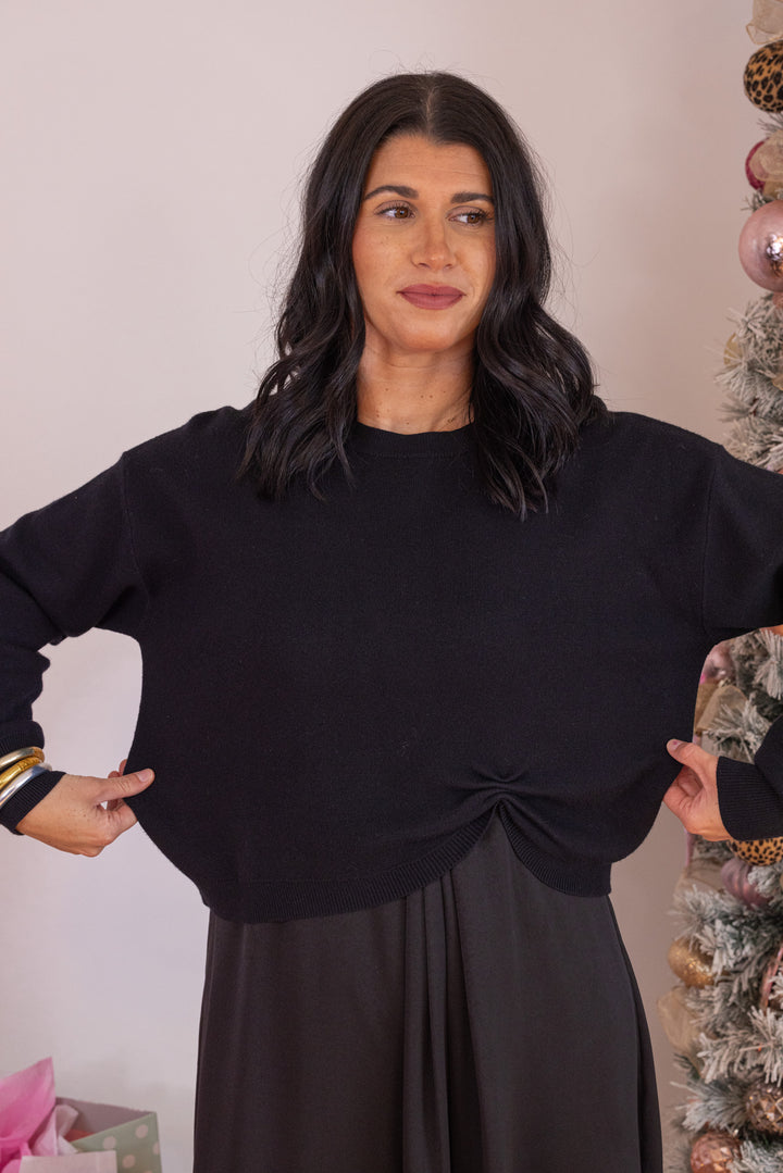 Women's black knit cropped sweater top with knotted detail at the hem by Jodifl showing true to size fit