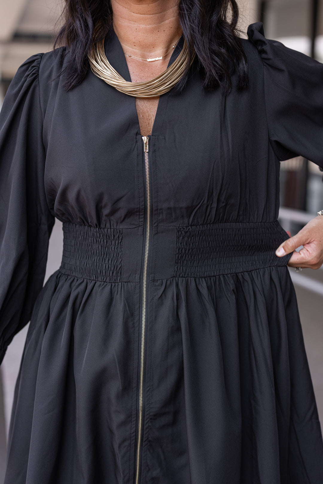 Women's black dress with zipper front closure by Umgee showing wide smocked waistband