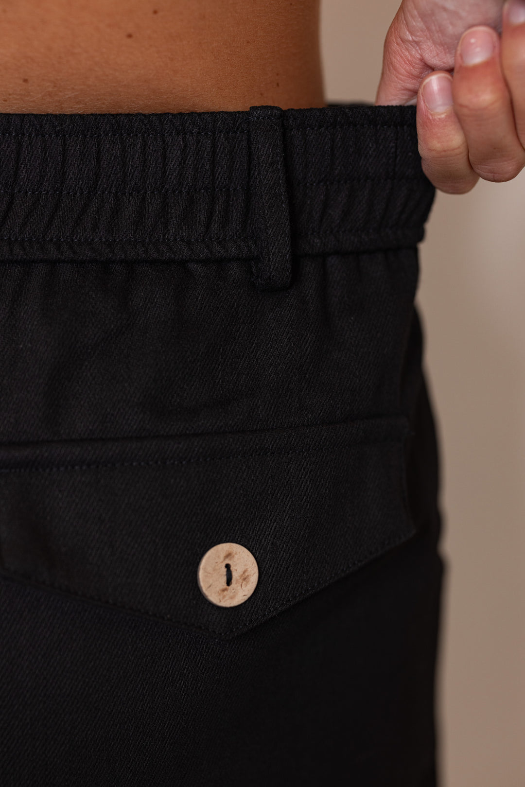 Women's black twill denim pintuck shorts by Entro showing elastic waistband in back