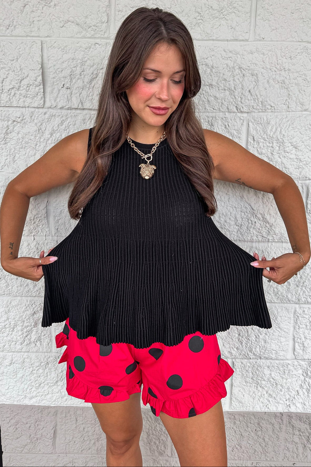 solid black crew neckline sleeveless peplum style relaxed silhouette ribbed knit top