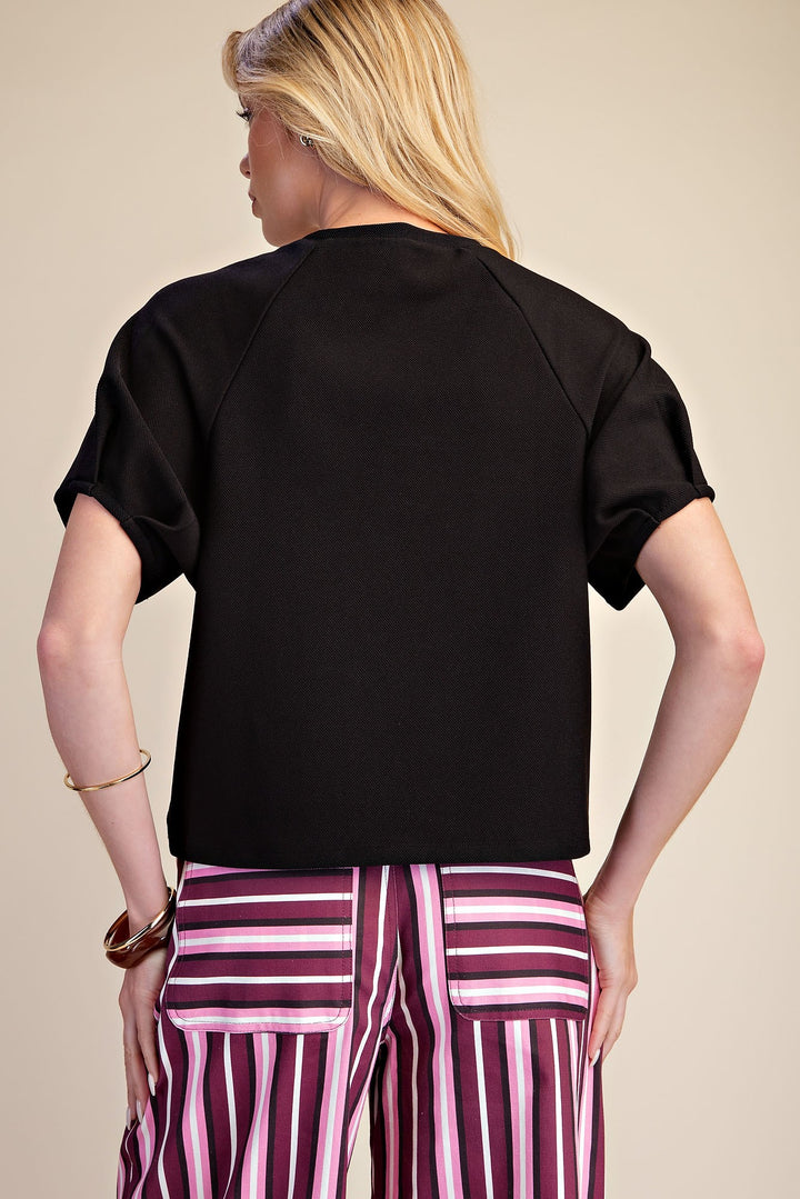 Black ribbed knit top with gathered puff sleeves in a flattering silhouette