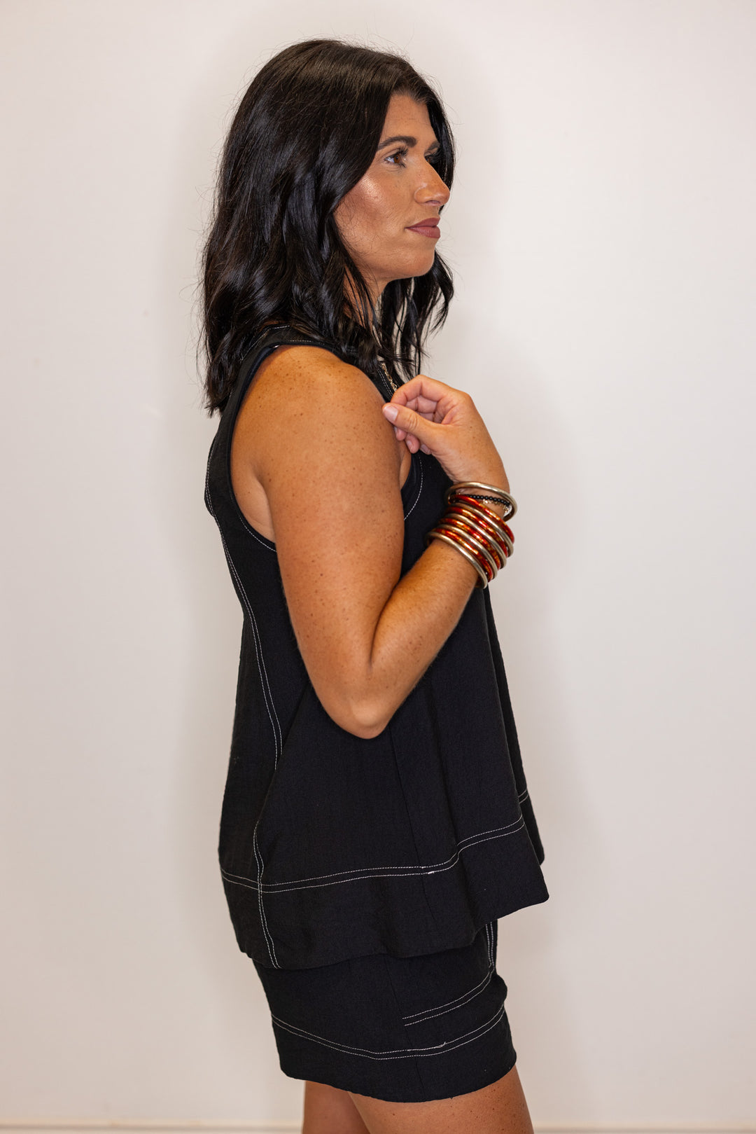 Black sleeveless top with white stitching by Entro showing up close side view