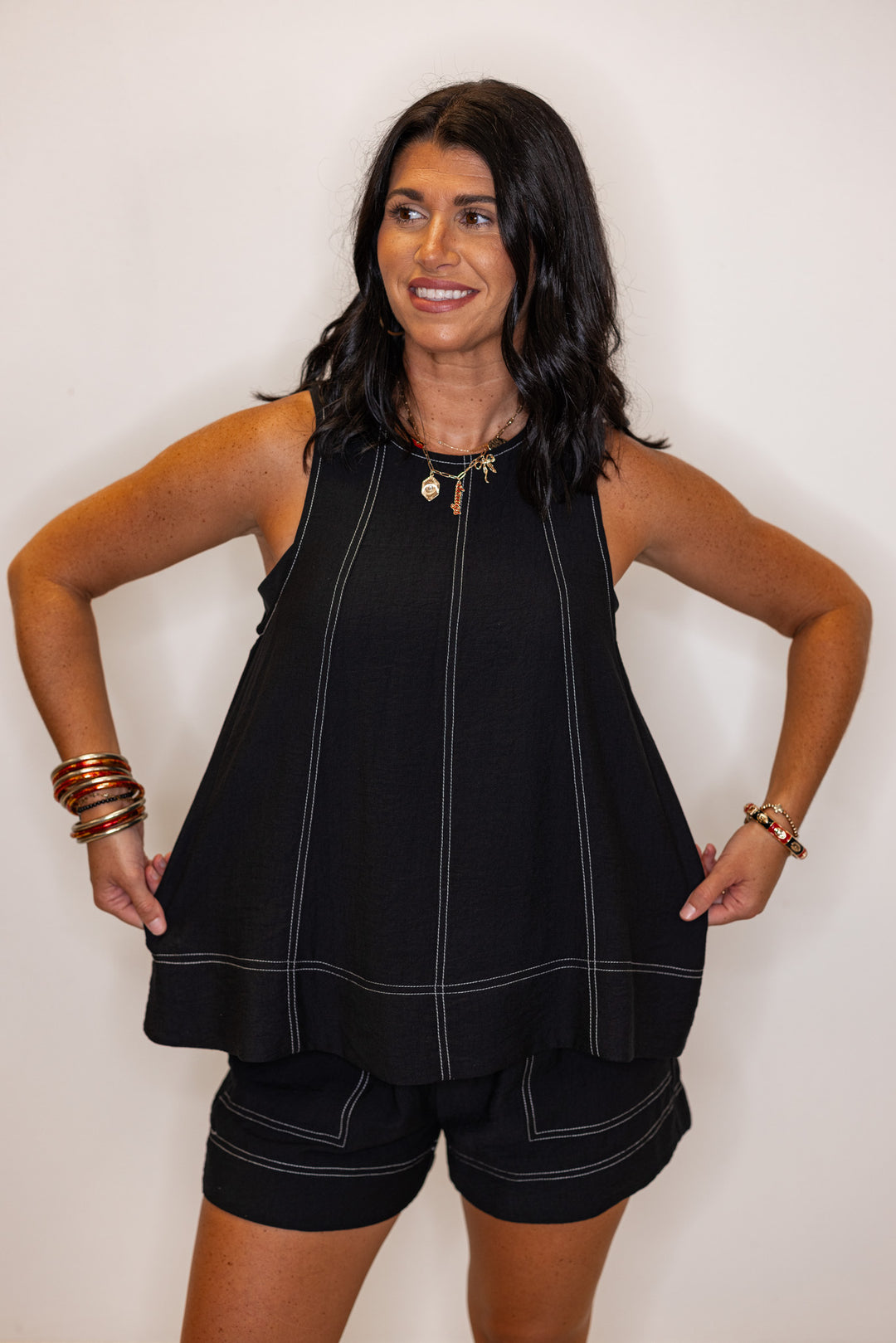 Black sleeveless top with white stitching by Entro showing relaxed silouhette