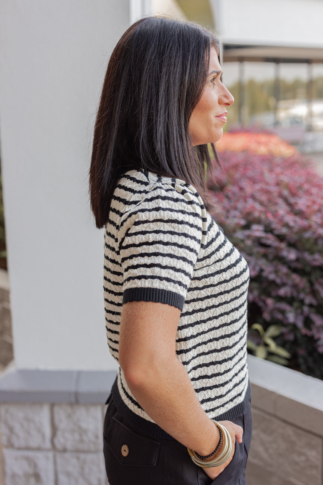 Women's black and cream striped knit top with scalloped trim by Entro showing up close side view