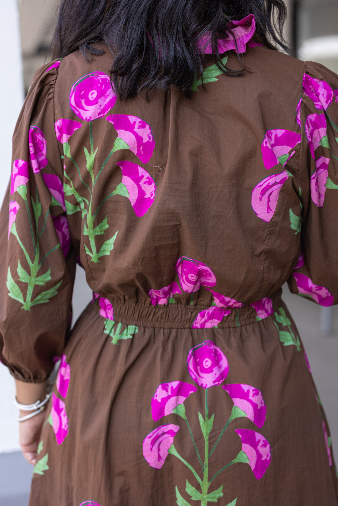 Women's brown midi dress with pink and green florals and pink ruffle trim by Umgee showing up close back view
