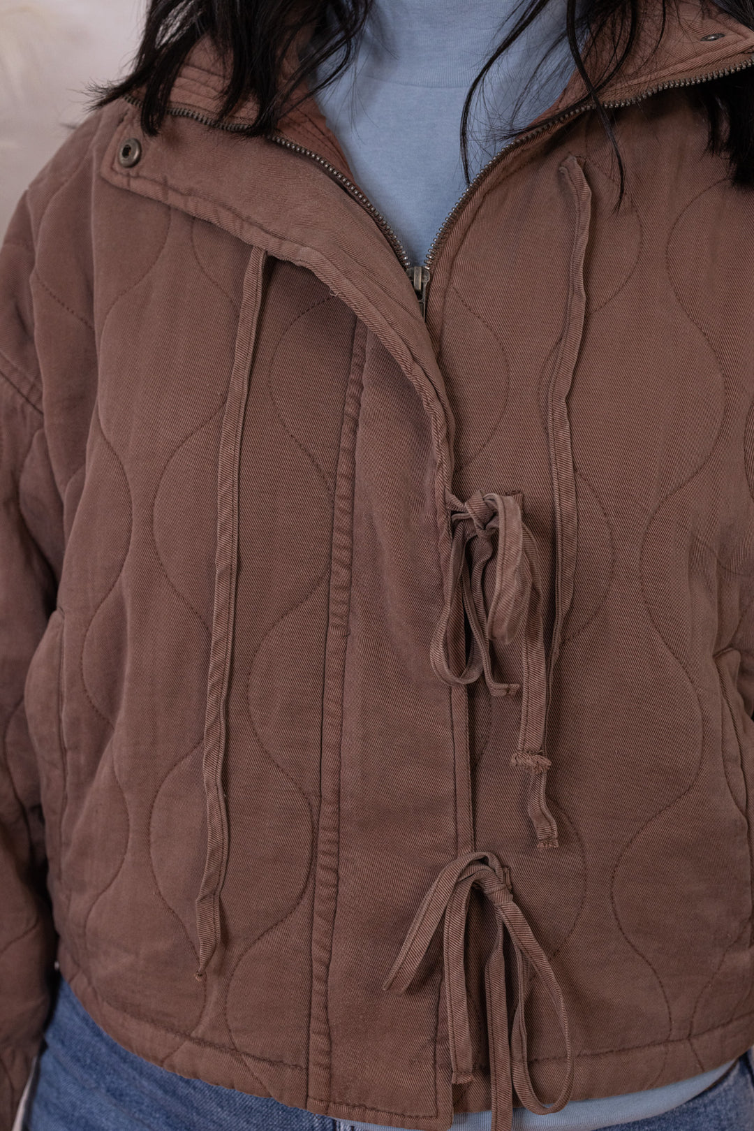 Women's washed brown quilted puffer jacket with bow ties down the front by Blu Pepper showing up close bodice view