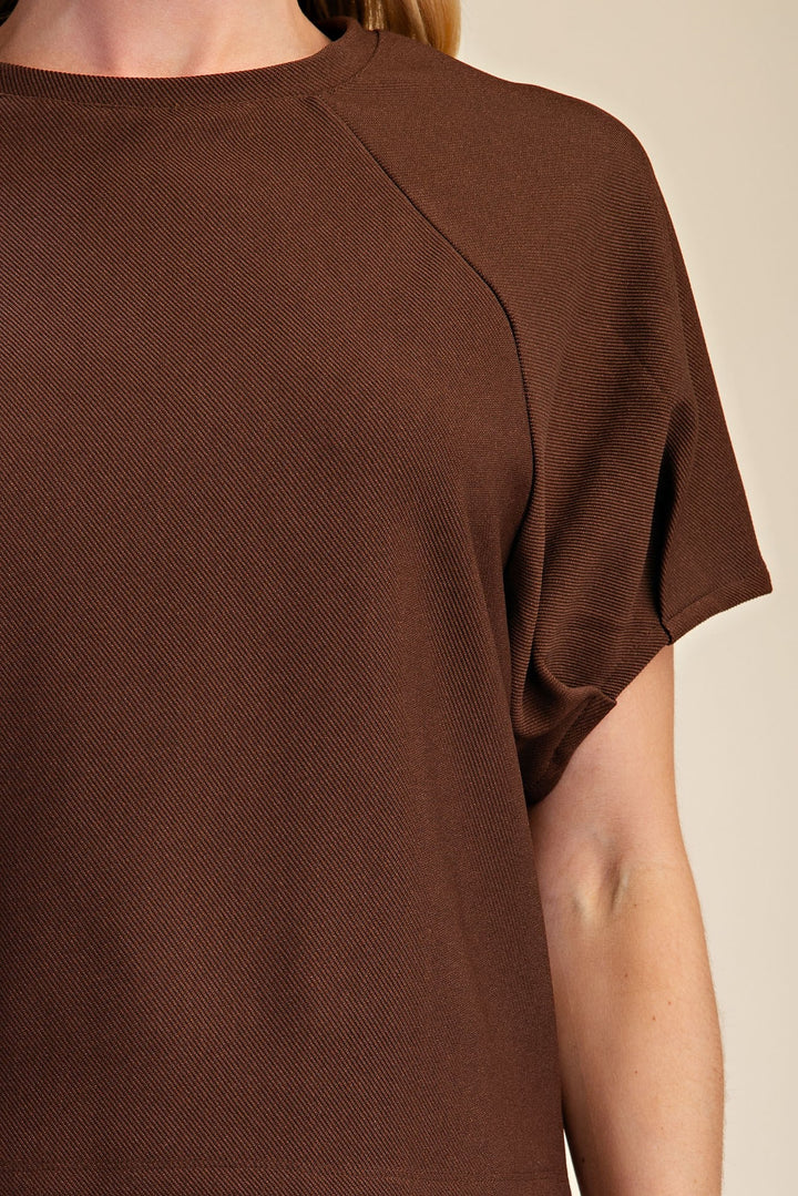 Brown knit top featuring gathered fabric puff sleeves