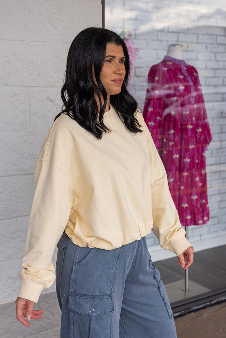 Women's butter pale yellow terry knit long sleeve pullover top with bubble hem by Wishlist showing up close side view