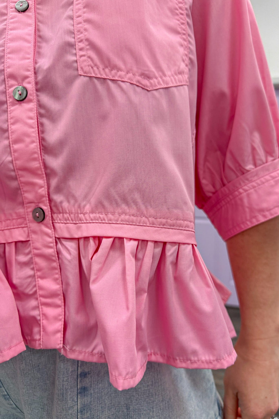 Women's Spring semi-cropped button down pink peplum top by Entro showing ruffled hem