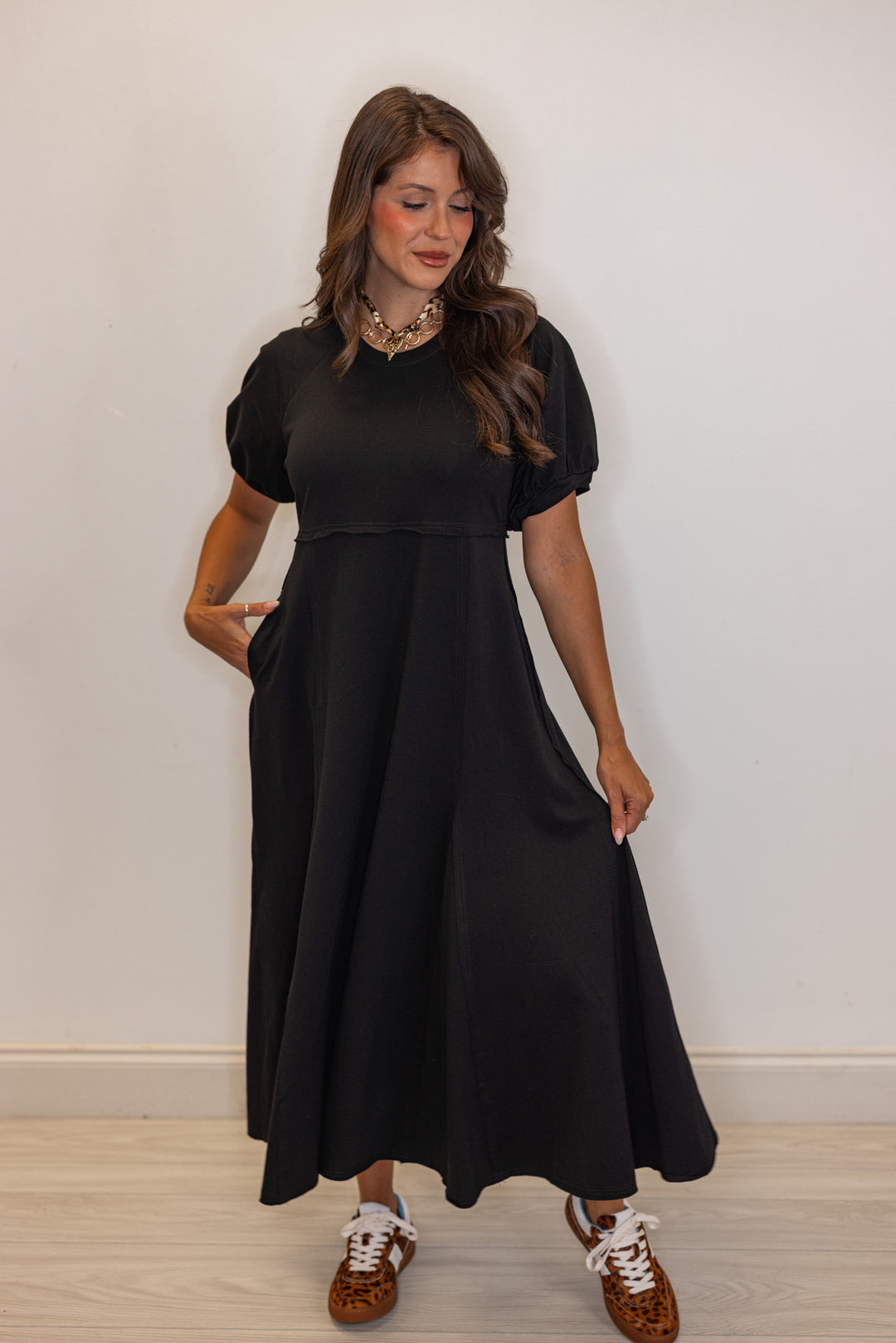 Black terry knit puff sleeve midi dress with raw seam details by Jodifl showing flowy skirt