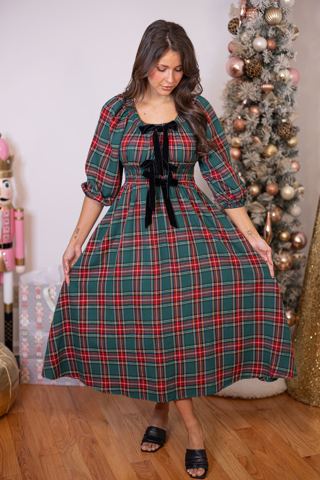Women's green and red plaid midi dress with black velvet bow ties down the bodice by Entro showing flowy skirt
