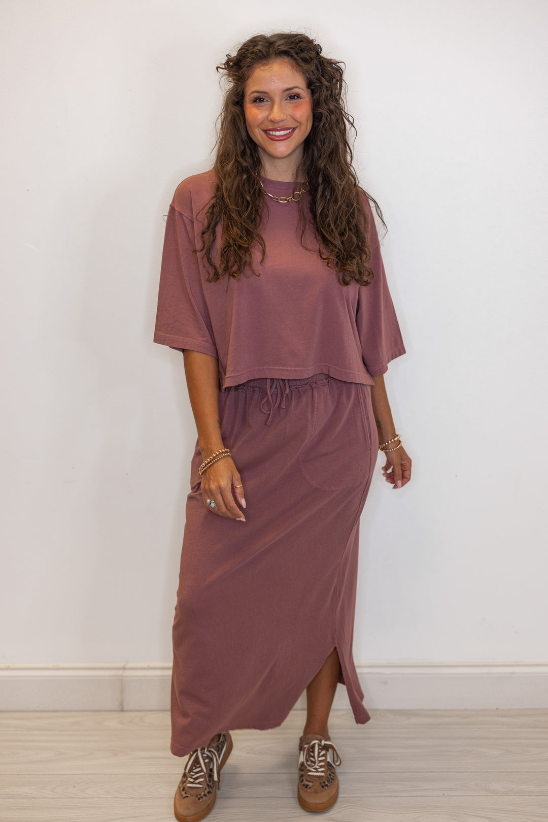 Women's dusty rose knit maxi skirt with matching crop top paired with leopard print sneakers
