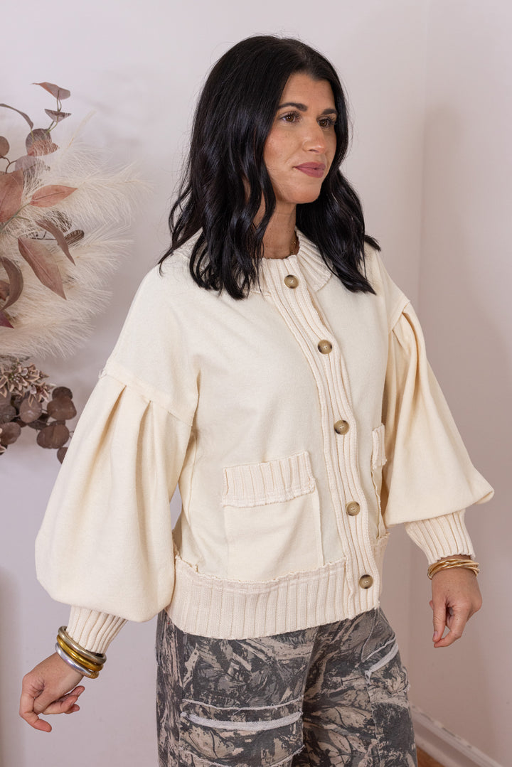 Women's ecru terry knit button front cardigan with textured ribbed knit trim by Entro showing slight side view