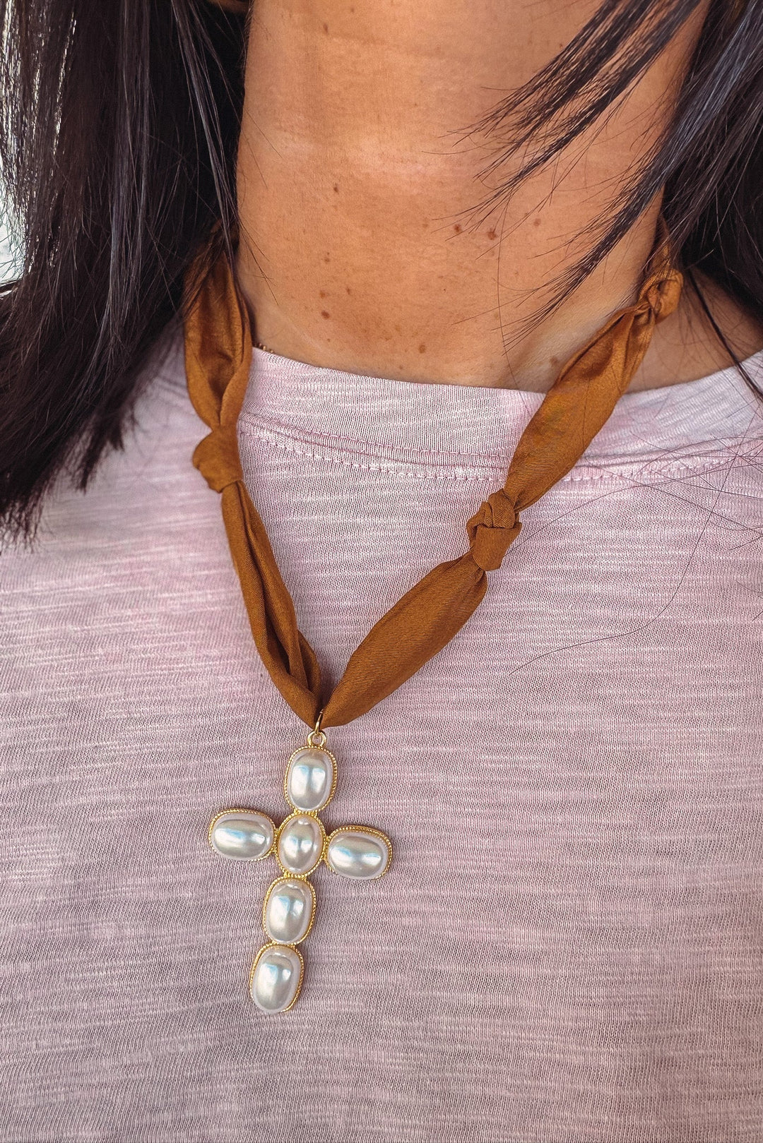 Brown scarf necklace with a cross pendant featuring pearls