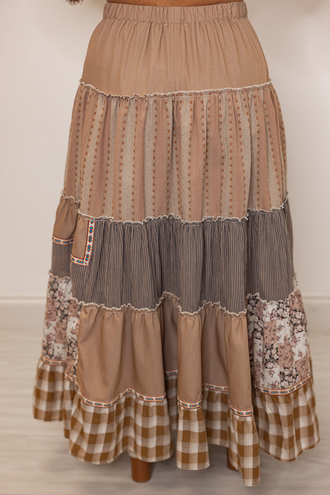 Back side of women's brown layered patterned boho maxi skirt with elastic waistband