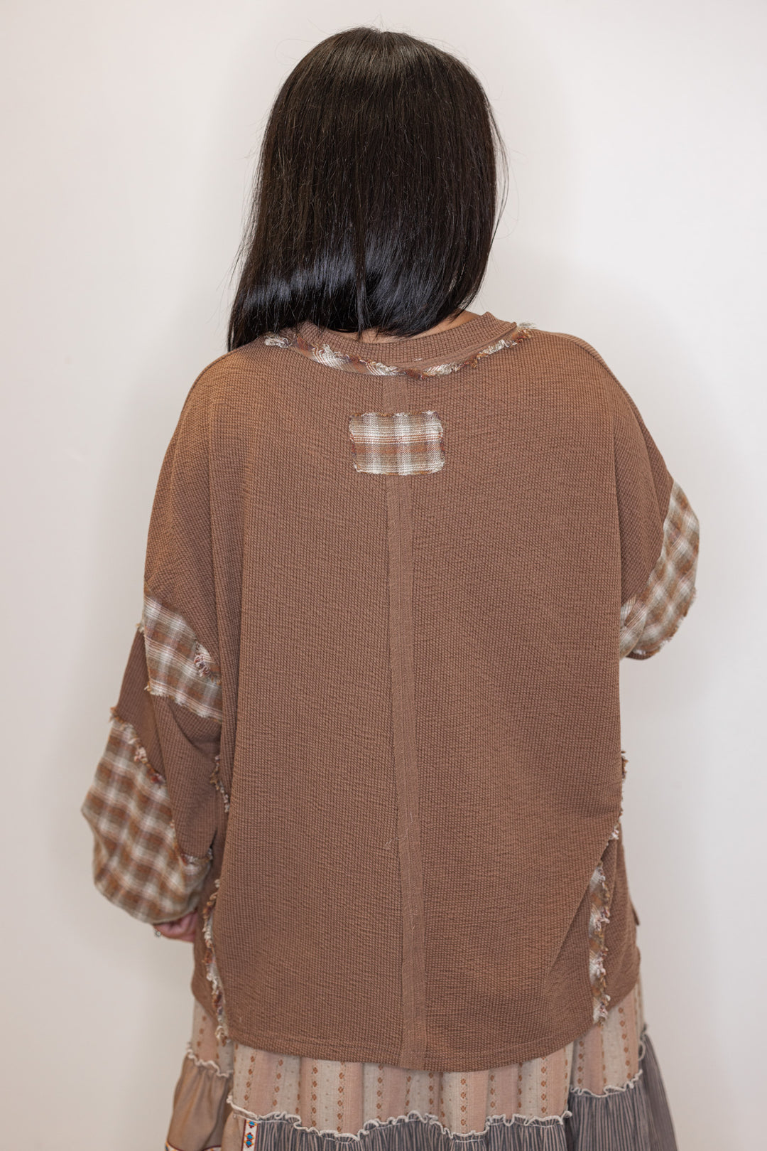 back view of brown knit and plaid trimmed top