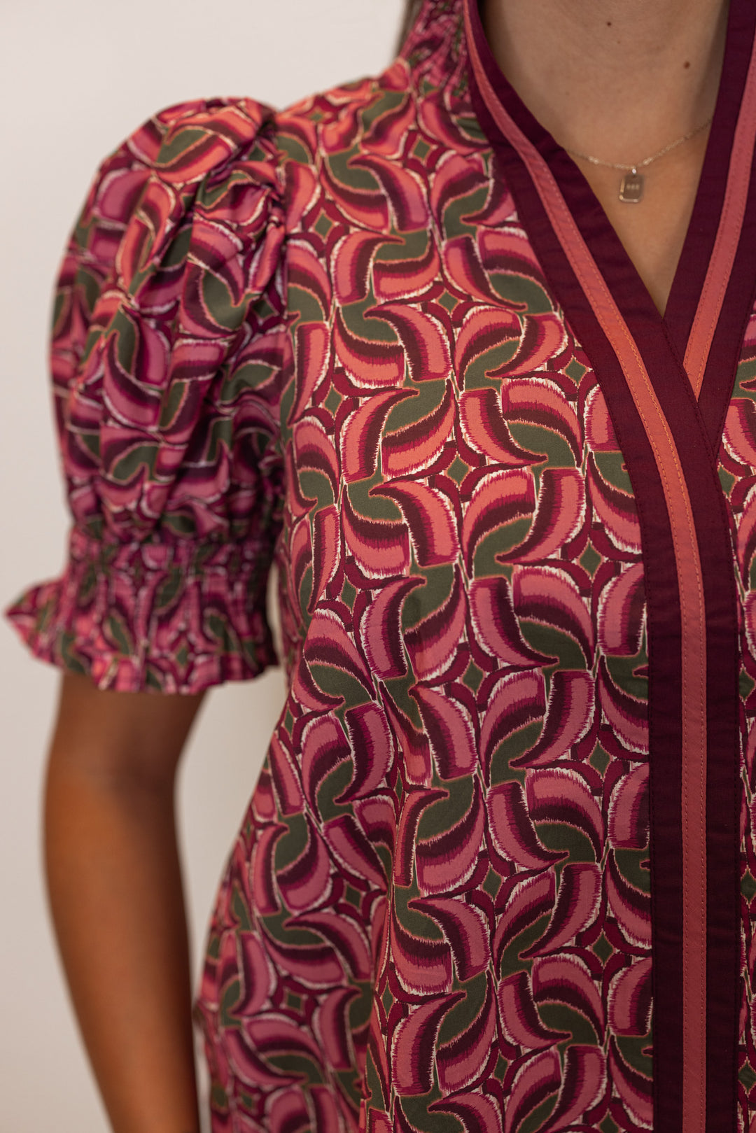 Women's burgundy wine poplin top with abstract print by Entro showing v neck detail and banded puff sleeves