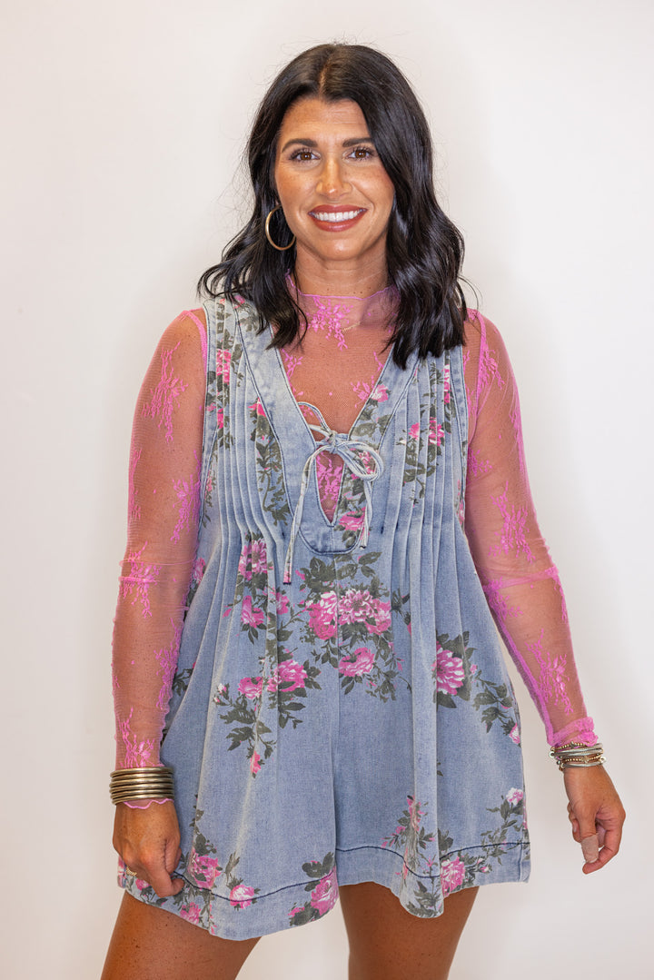 Women's washed blue denim floral romper with ruched bodice and bow tie v neck by Veveret showing up close front view