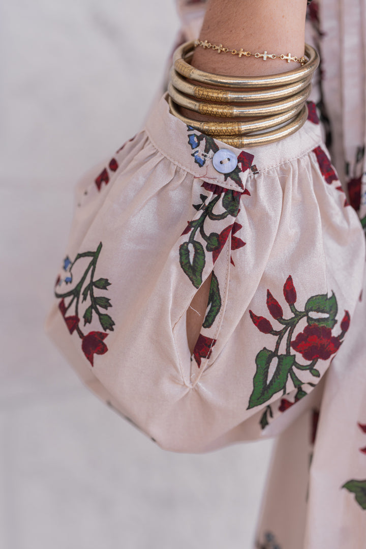 Women's ecru and burgundy floral print babydoll top with pleats and ruffle details by Entro showing button cuff on sleeves