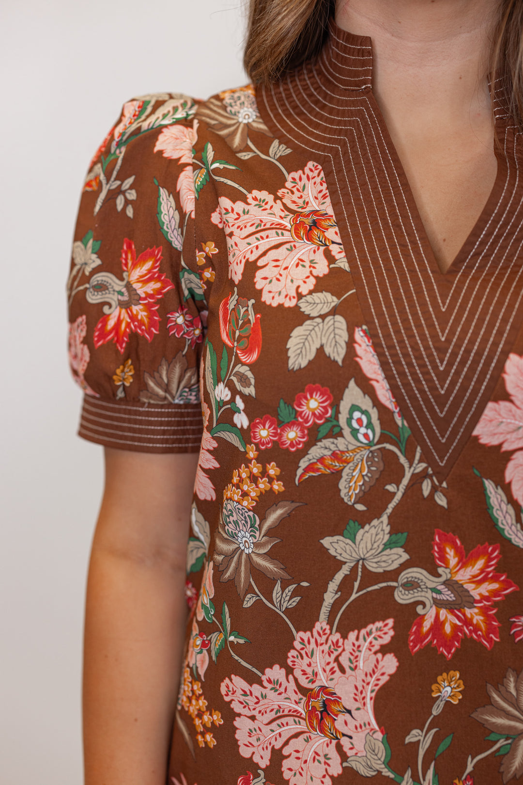 Women's brown multicolor floral print dress with stitching trim detail by Entro showing up close view of v neckline
