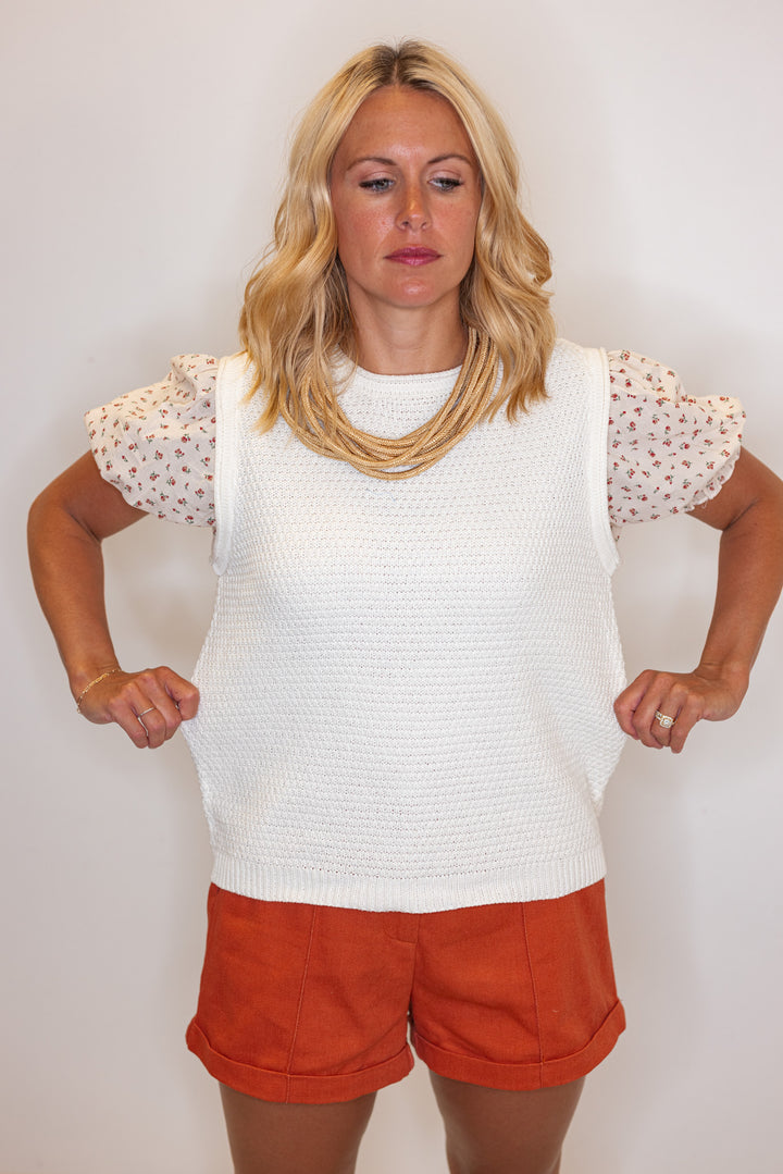 Cream lightweight textured sweater knit top with red floral print puff sleeves by Wishlist showing fabric's stretch