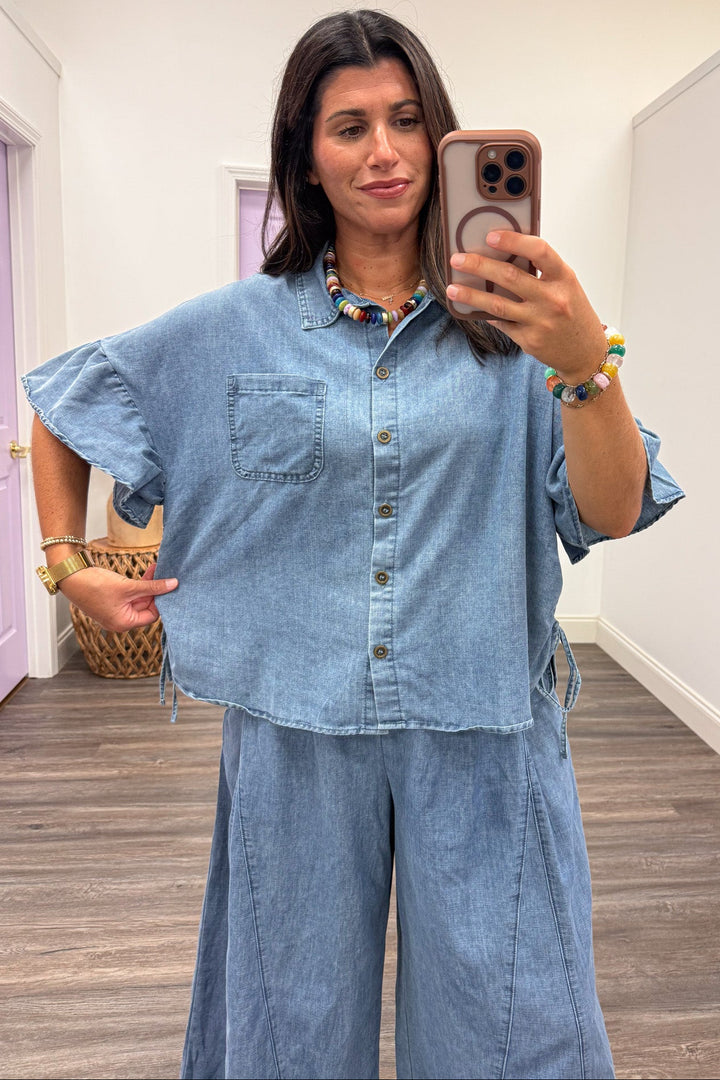 washed blue denim button front short sleeve relaxed silhouette top with cinch drawstring sides