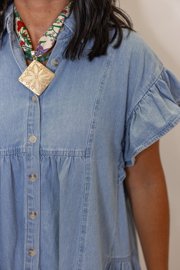 Women's light blue denim button down swing dress by Entro showing short sleeves with ruffle trim
