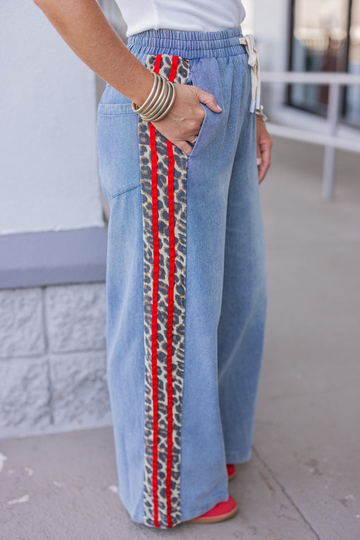 Women's blue denim wide leg pants with red ribbon and brown leopard print sides by Easel