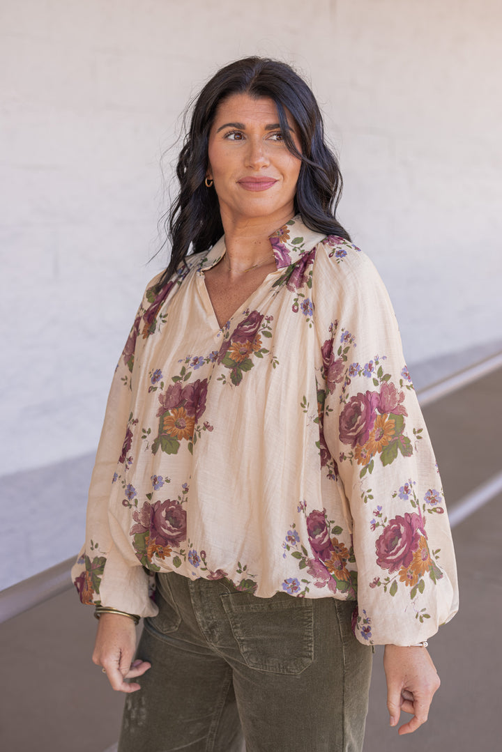 Women's ecru bubble hem top with large burgundy and olive floral print by Entro showing slight side view