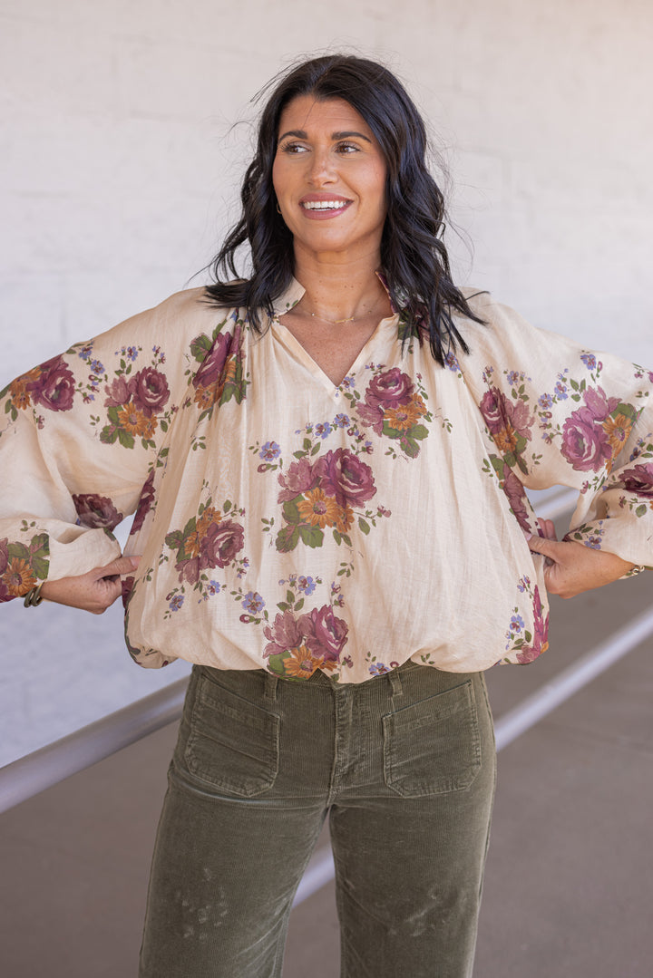 Women's ecru bubble hem top with large burgundy and olive floral print by Entro showing true to size fit and semi cropped length