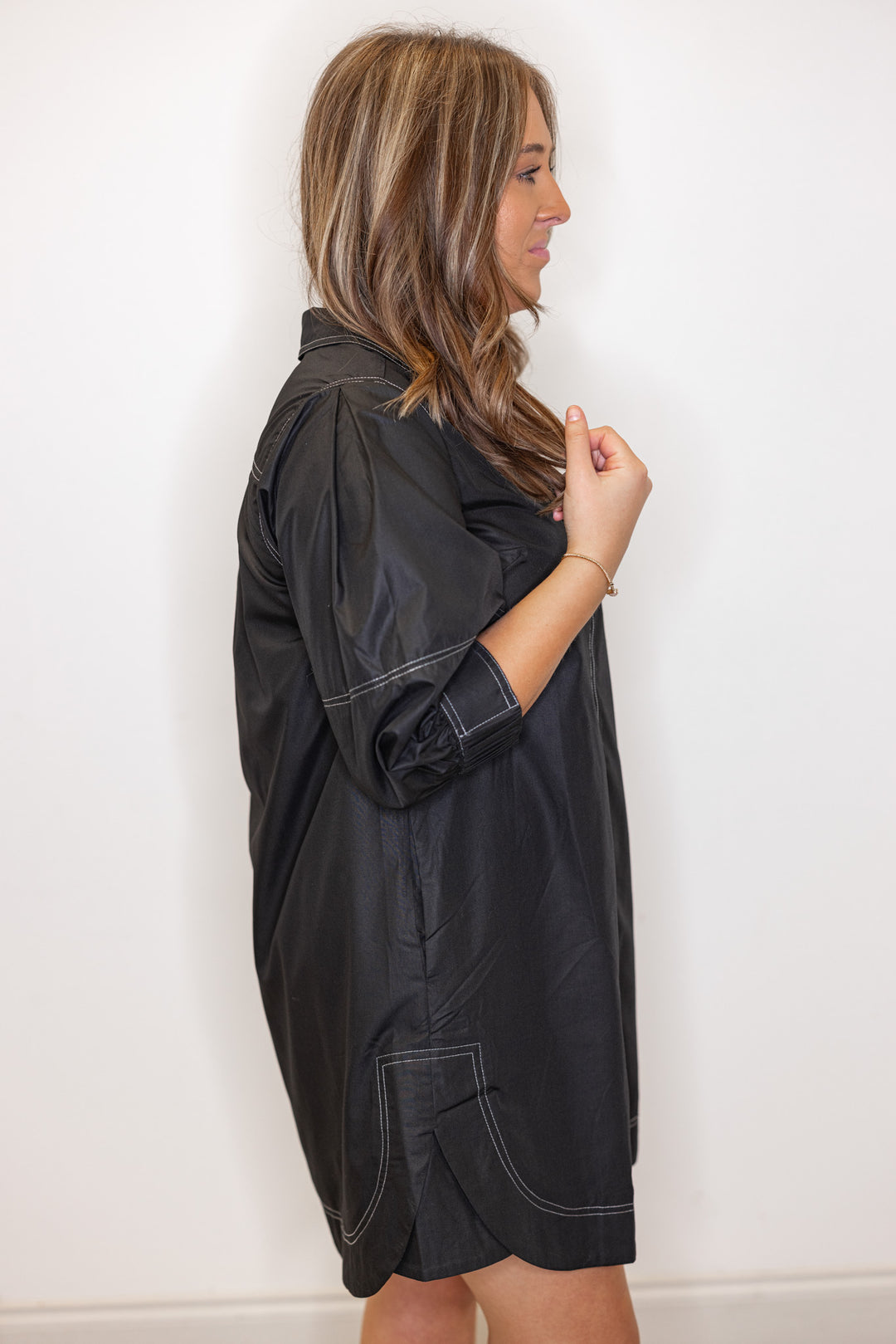 Women's black mini dress with cream contrasting stitching throughout by Entro showing up close side view