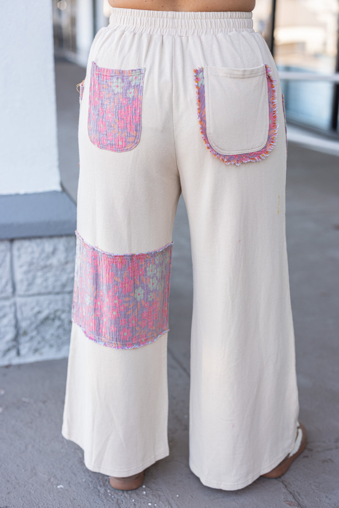 Women's french terry knit oatmeal pants with frayed floral patch gauze details by Easel showing back view