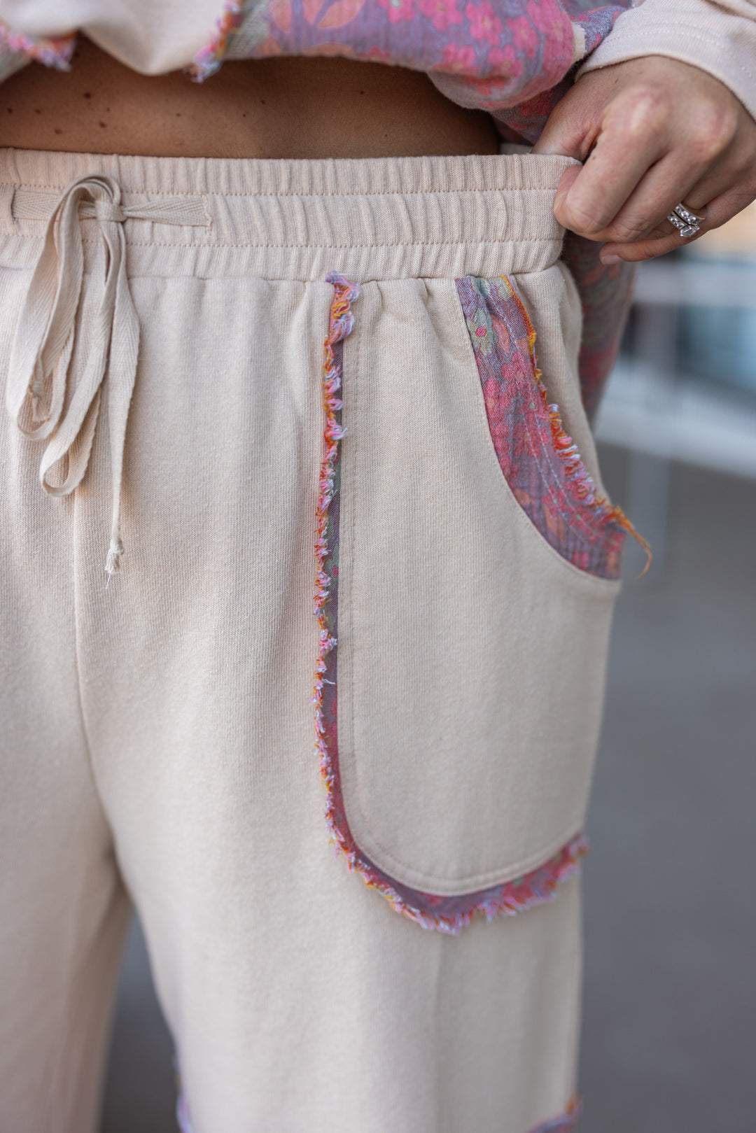 Women's french terry knit oatmeal pants with frayed floral patch gauze details by Easel showing elastic waistband 