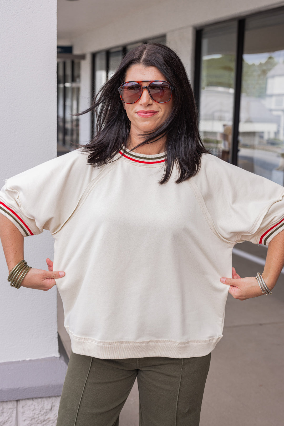 Women's ecru french terry knit top with olive and red striped trim by Entro showing true to size fit