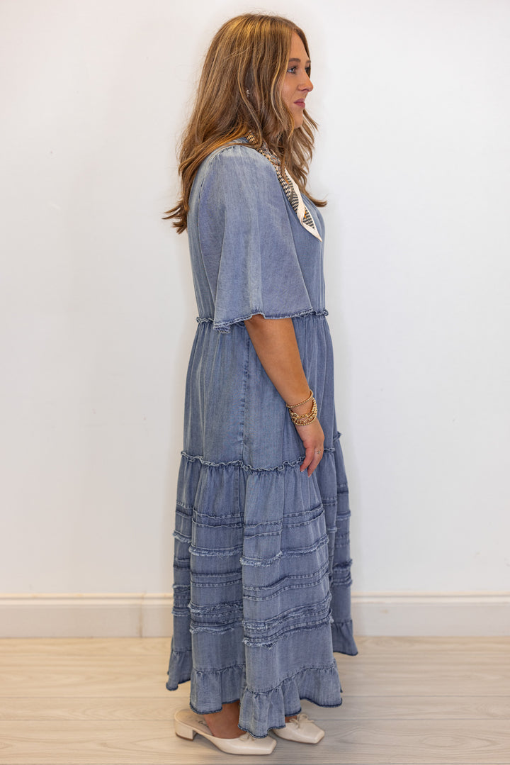 Women's washed blue chambray denim ruffle tiered midi dress with frayed details by Easel showing full side view