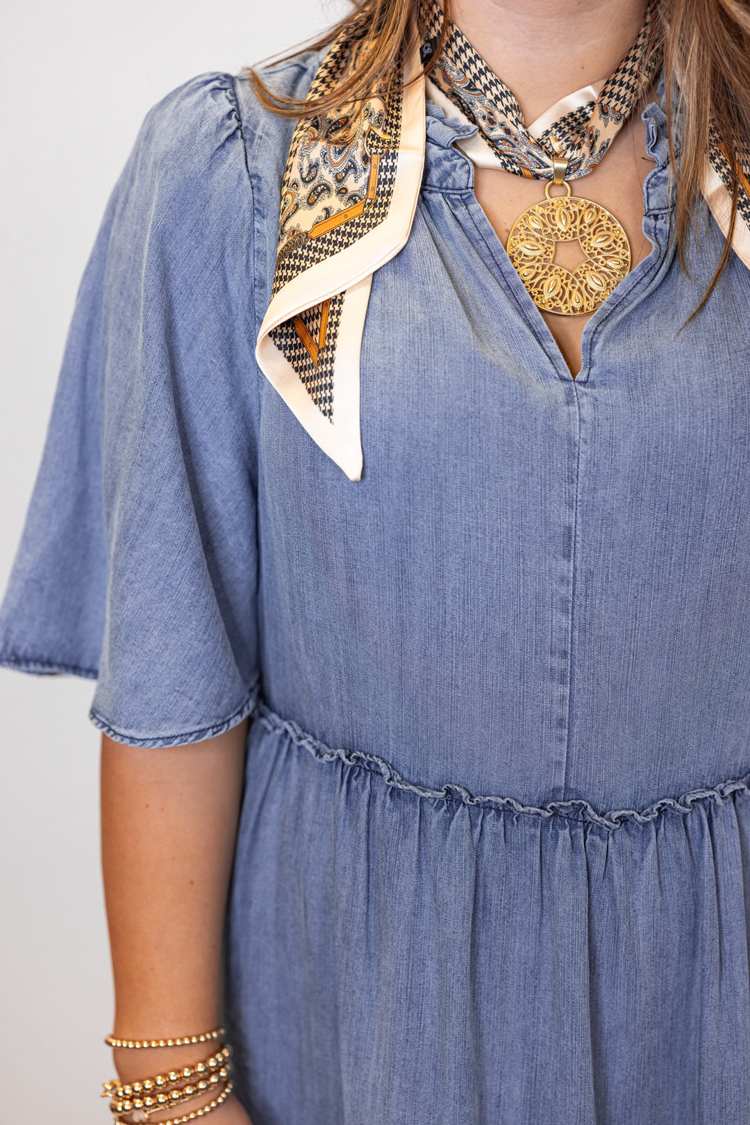 Women's washed blue chambray denim ruffle tiered midi dress with frayed details by Easel showing v neckline 