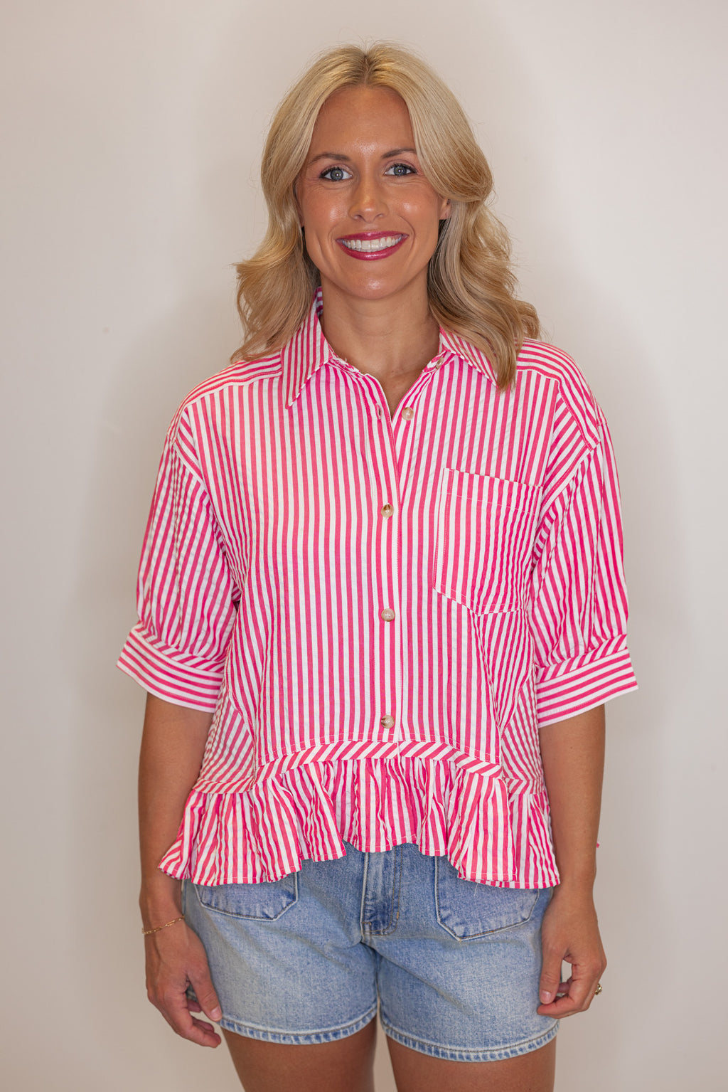Women's pink summer striped button down top with ruffled bottom hem by Entro