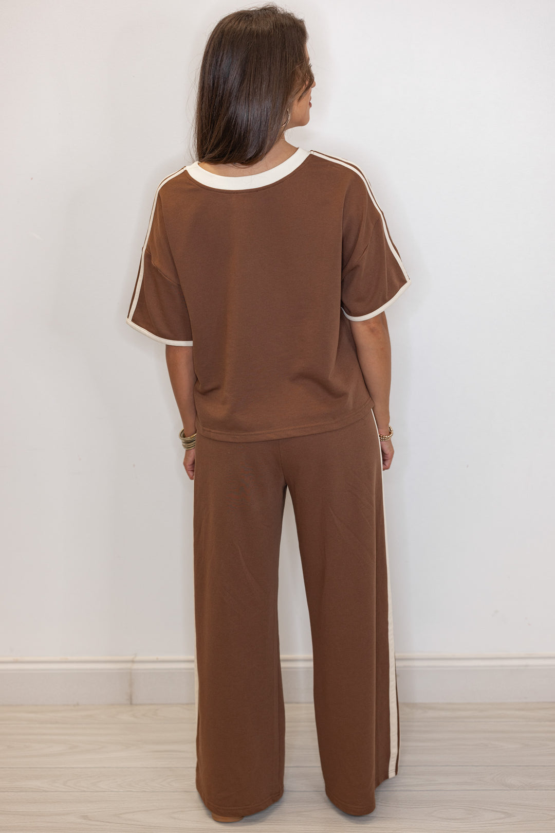 Women's brown french terry knit wide leg pants with cream stripes on the side by Entro showing full back view