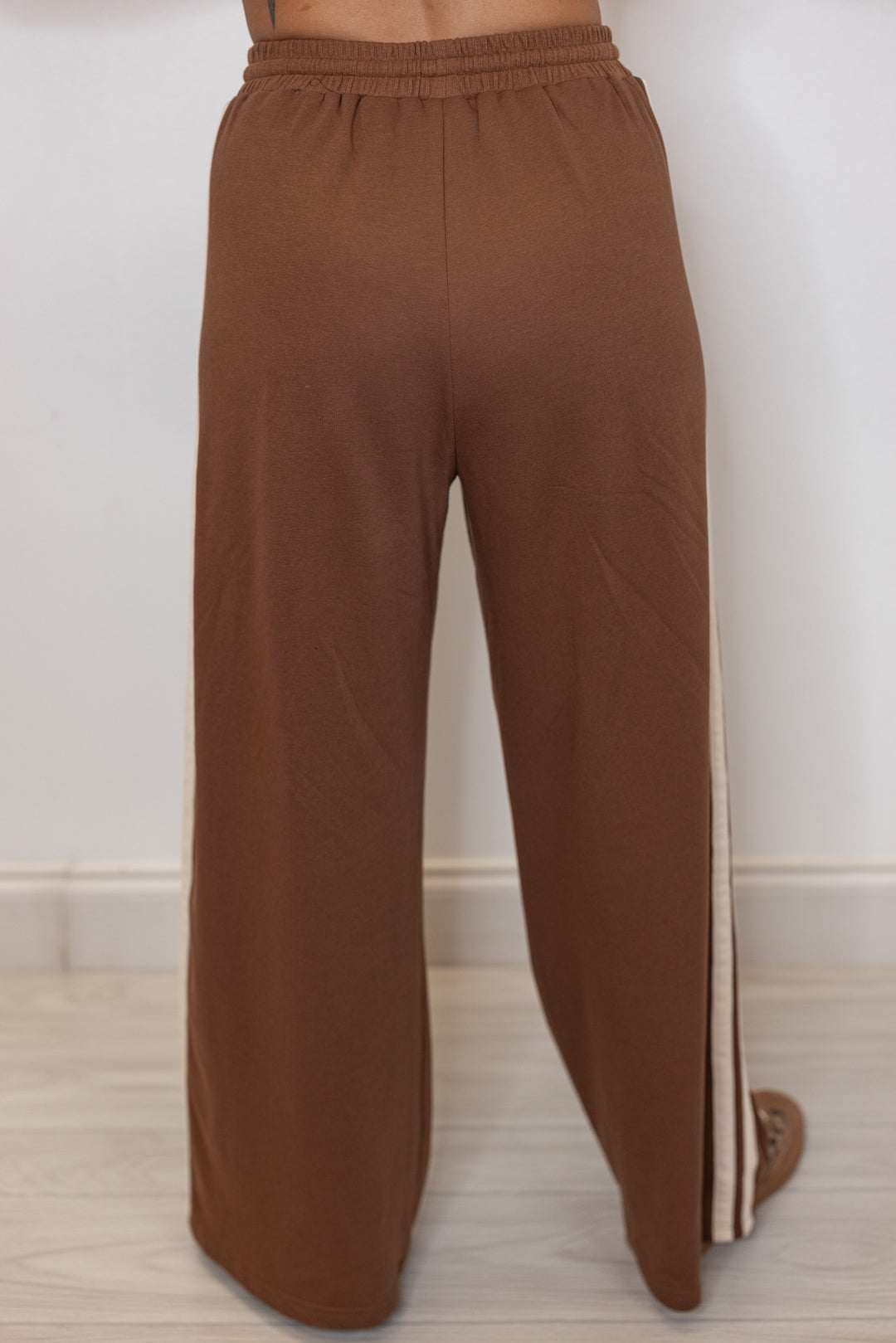 Women's brown french terry knit wide leg pants with cream stripes on the side by Entro showing up close back view