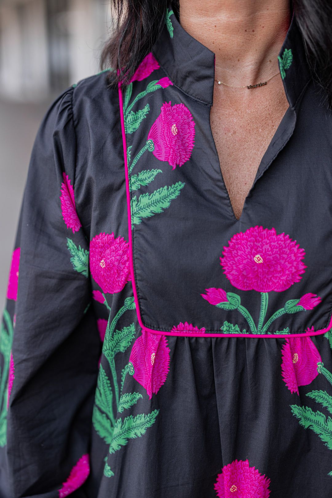 Women's black midi dress by Jodifl showing up close view of hot pink floral print and hot pink piping trim