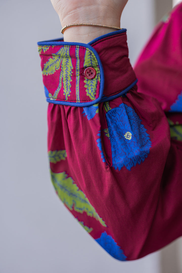 Women's burgundy midi dress with dark blue floral print and dark blue piping trim by Jodifl showing up close view of sleeve detail