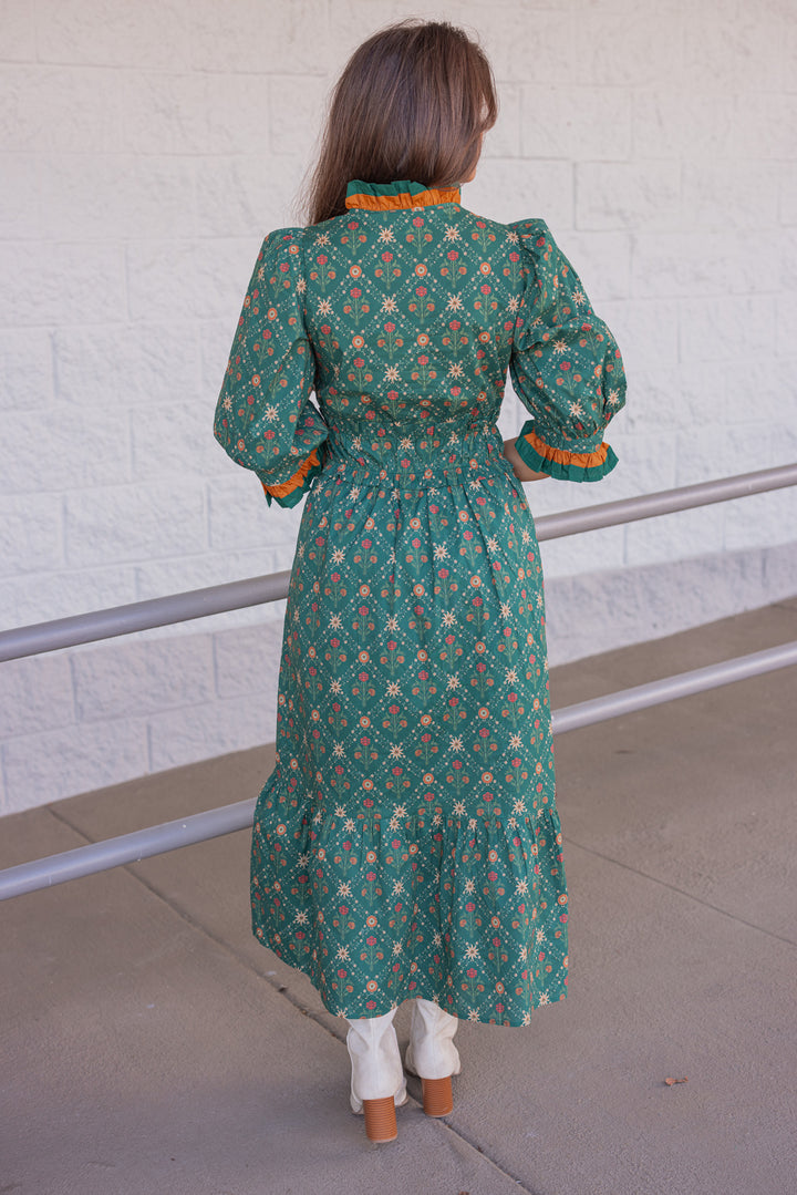 Women's hunter green midi dress with rust and taupe floral print and ruffle trim by Entro showing back view