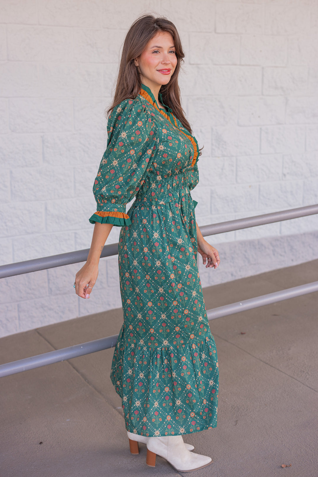 Women's hunter green midi dress with rust and taupe floral print and ruffle trim by Entro showing side view