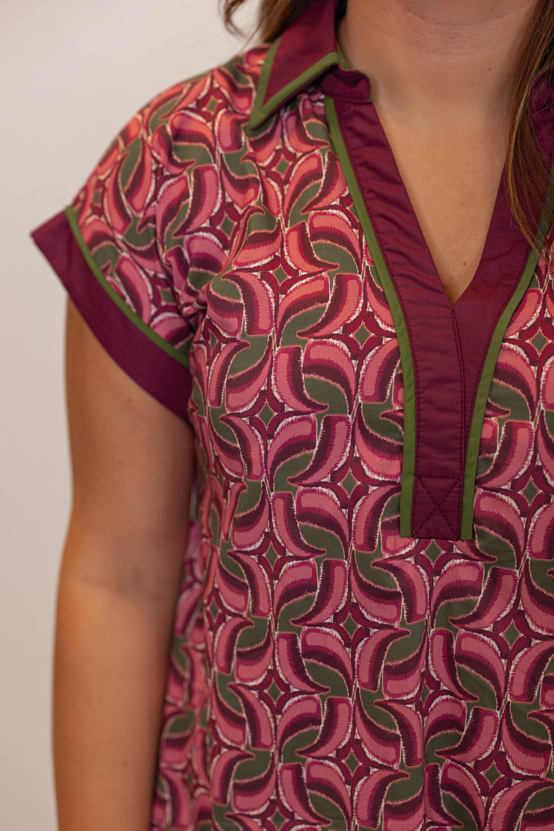 Women's burgundy, salmon and olive green abstract print dress by Entro showing collared v neckline