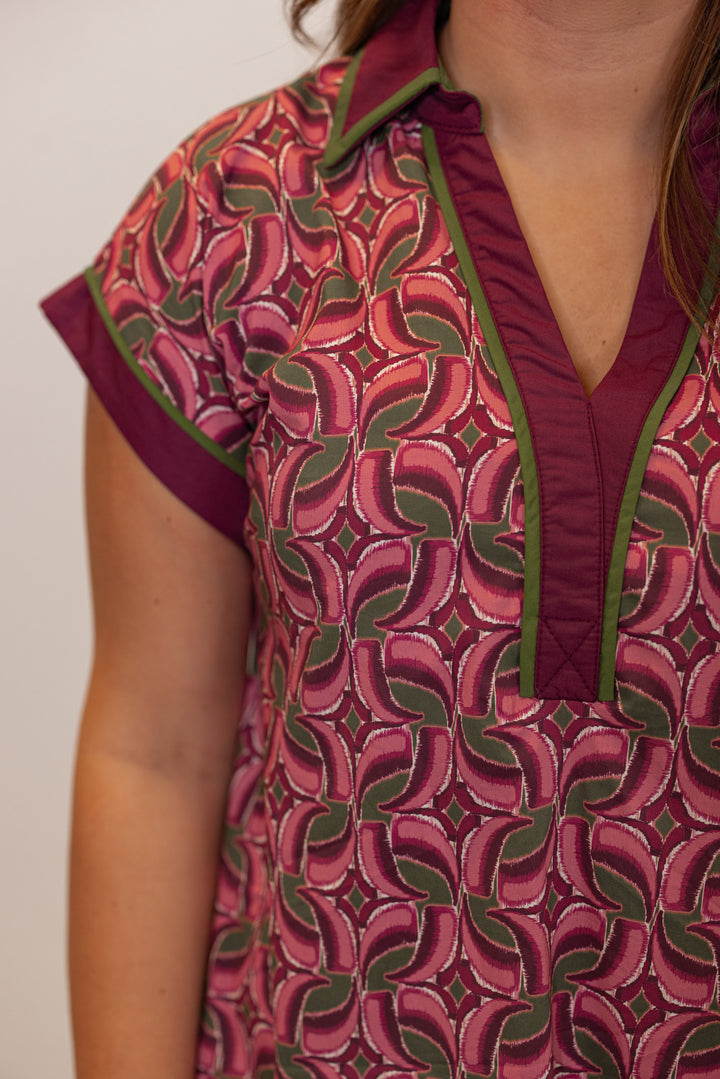 Women's burgundy, salmon and olive green abstract print dress by Entro showing collared v neckline