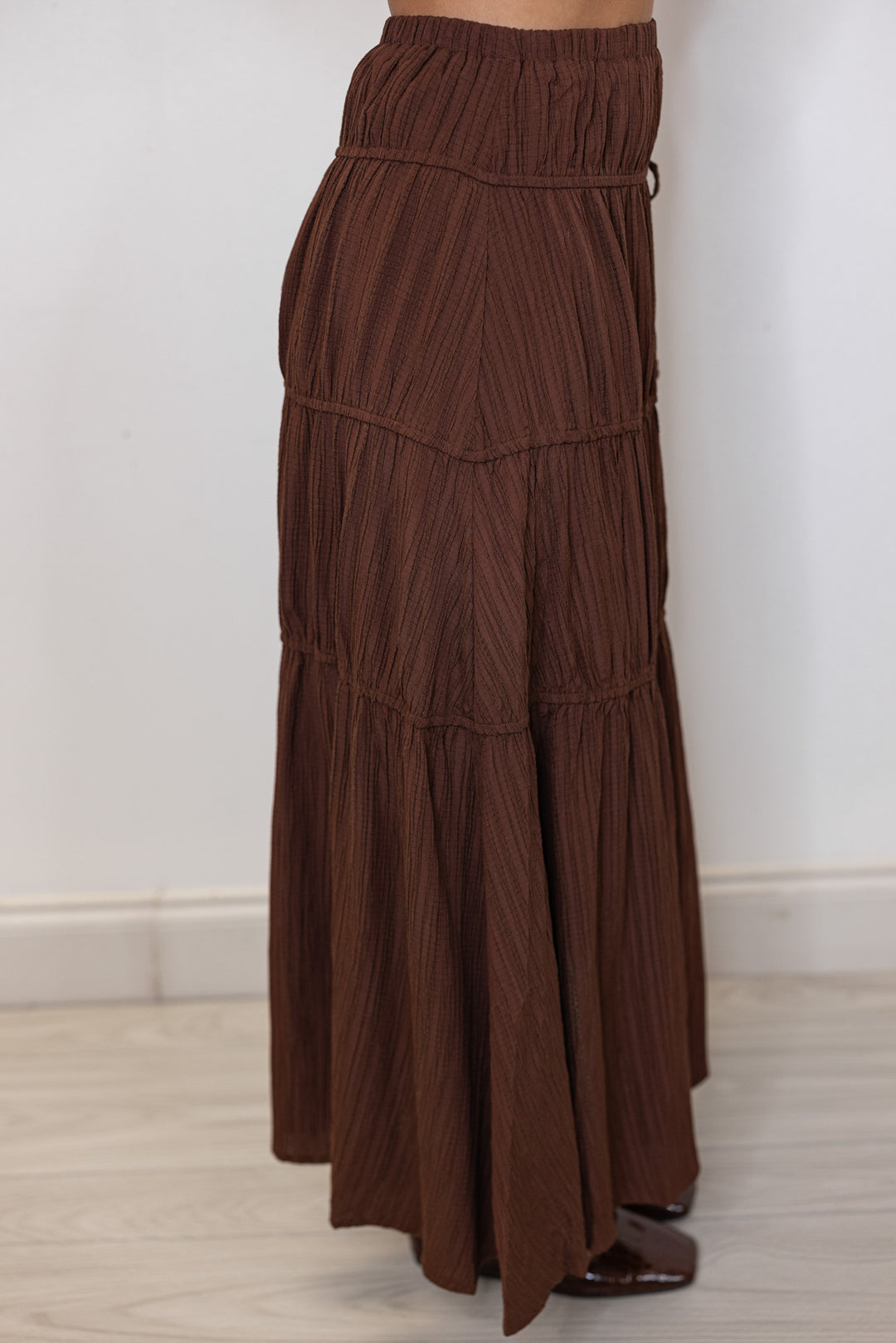Women's pleated chocolate brown tiered midi skirt with bow ties down one side by In February showing up close, side view