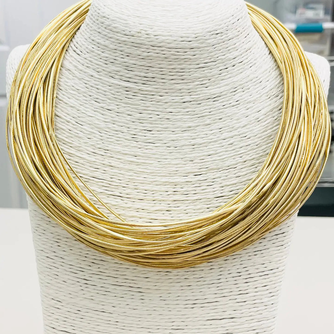 Gold necklace on a white mannequin bust