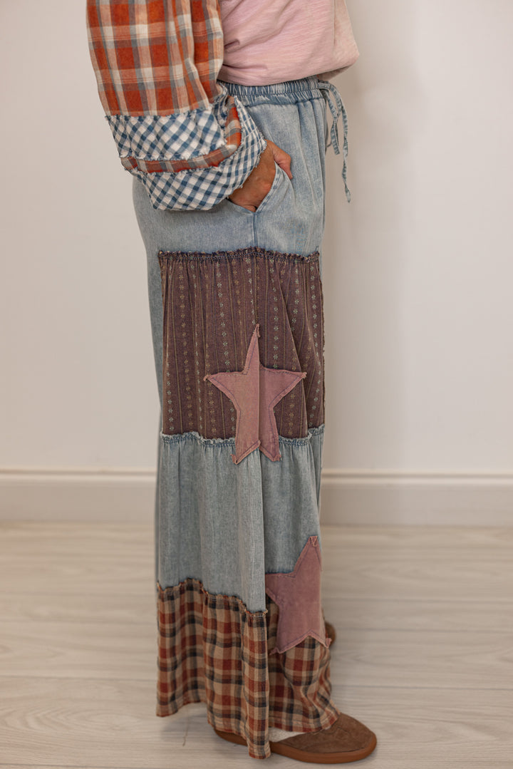 Side view of women's patchwork denim pants with star patterns and side pockets