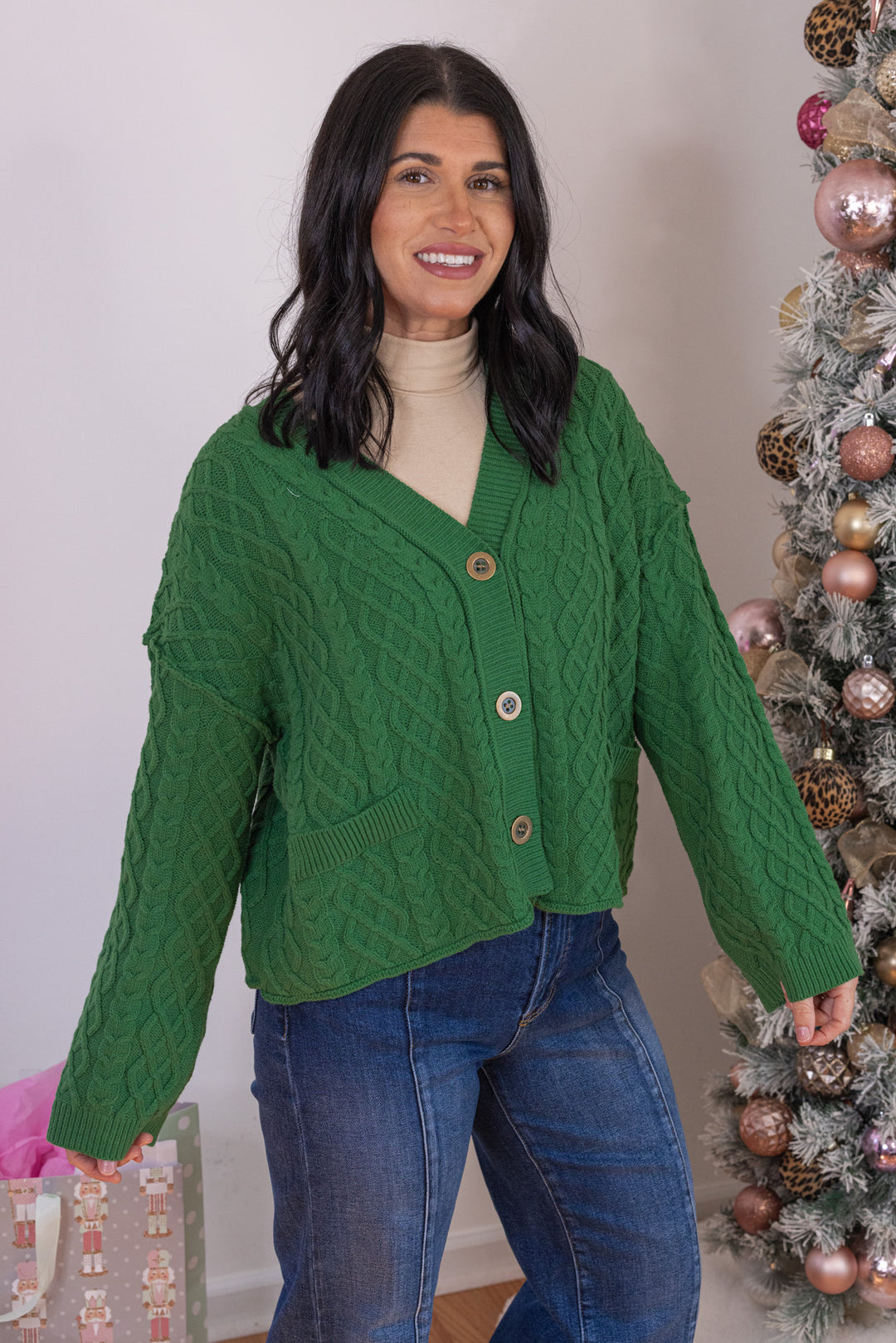 Women's cable knit button front sweater cardigan in forest green with ribbed trim by Entro showing up close front angled view