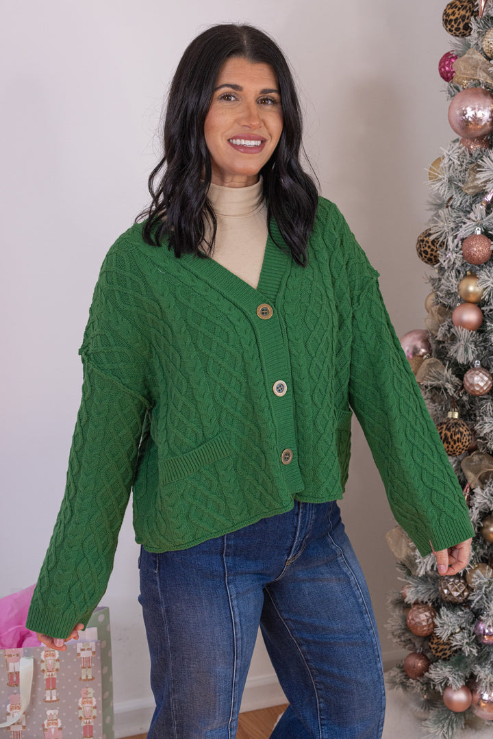 Women's cable knit button front sweater cardigan in forest green with ribbed trim by Entro showing up close front angled view